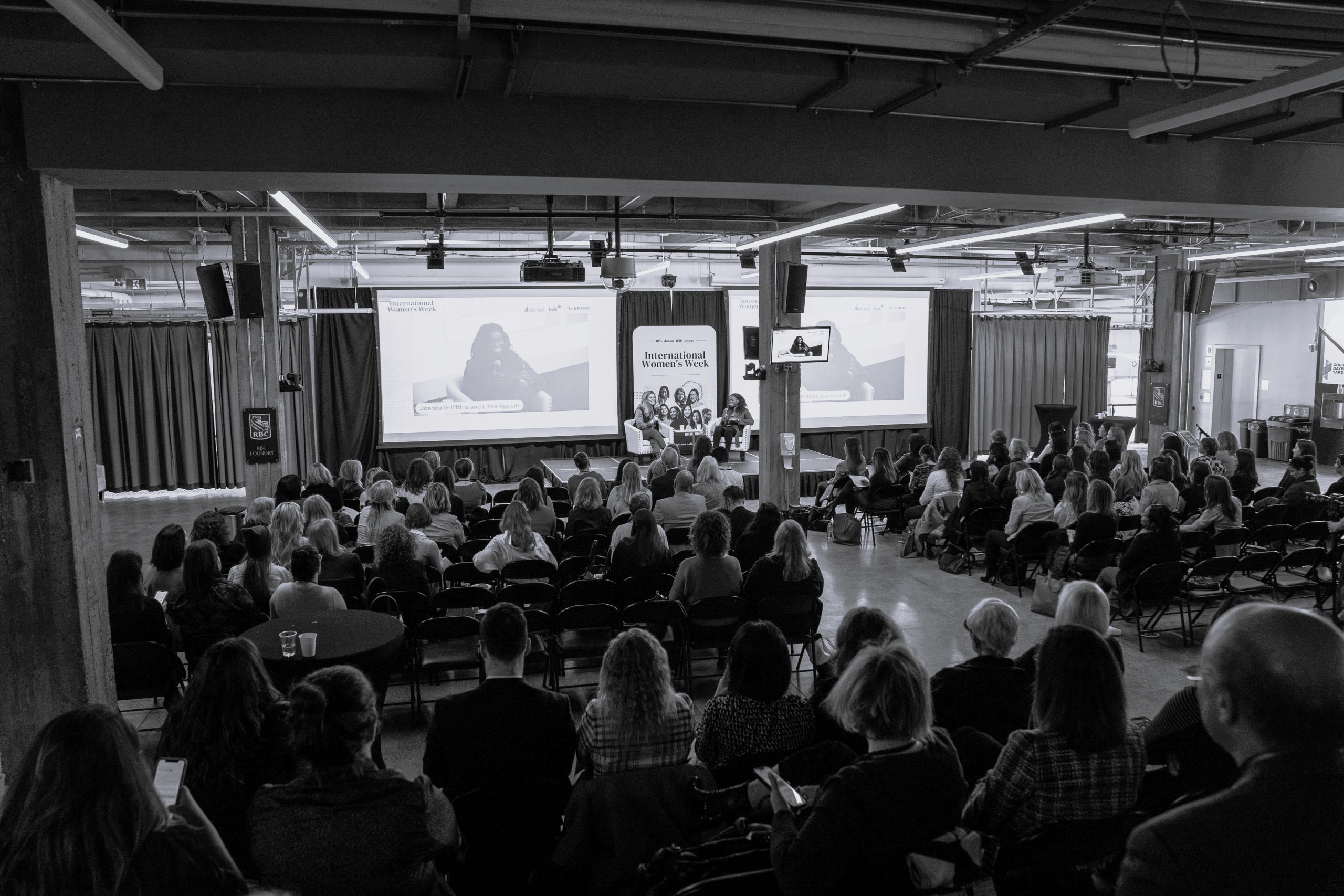 A speaker presenting to a seated audience at a past conference